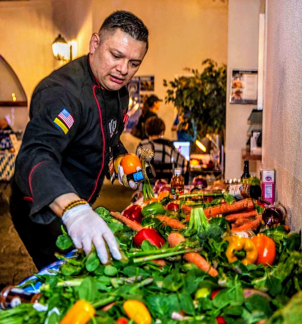 Chef Oscar Sanchez arranging a large fresh produce and crudité display